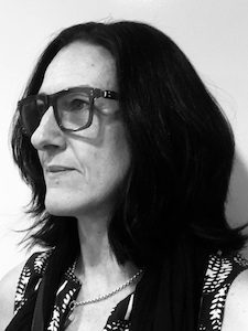 Image of person, in black and white, with glasses on looking to the left